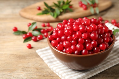 Photo of Tasty ripe cranberries on wooden table, closeup