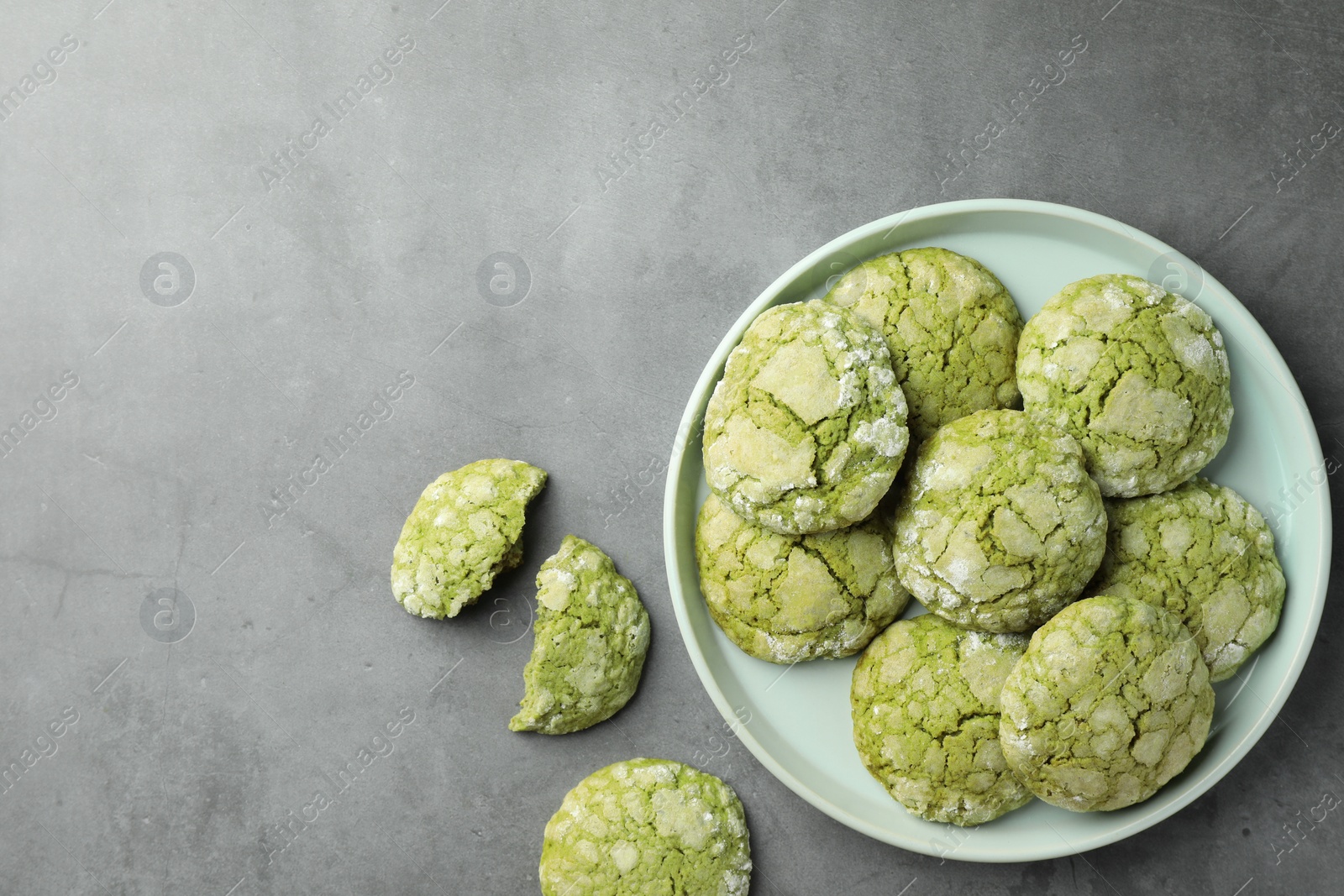 Photo of Plate with tasty matcha cookies on grey table, flat lay. Space for text