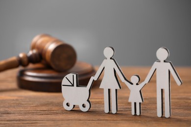 Family law. Figure of parents with children and gavel on wooden table