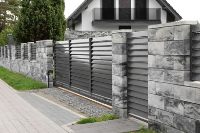 Photo of Metal gates near marble columns and house outdoors