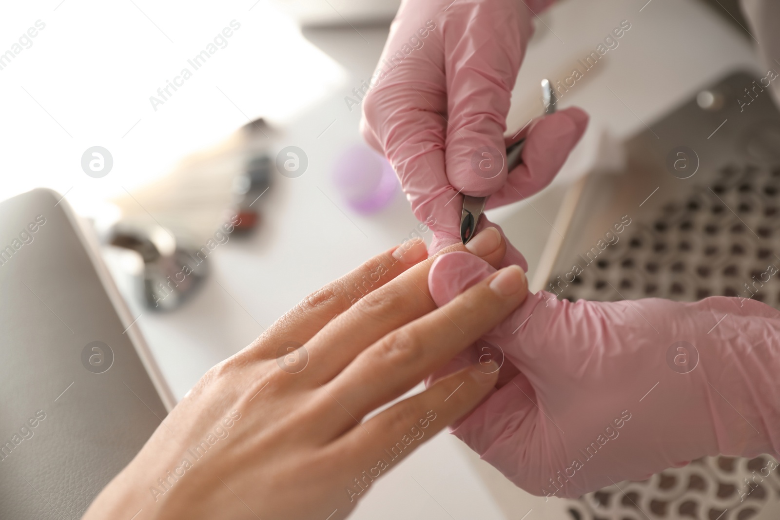 Photo of Professional manicurist working with client in beauty salon, above view
