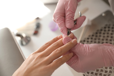 Photo of Professional manicurist working with client in beauty salon, above view