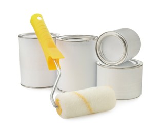 Photo of Closed blank cans of paint and roller brush on white background