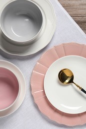 Photo of Beautiful ceramic dishware and spoon on wooden table, top view