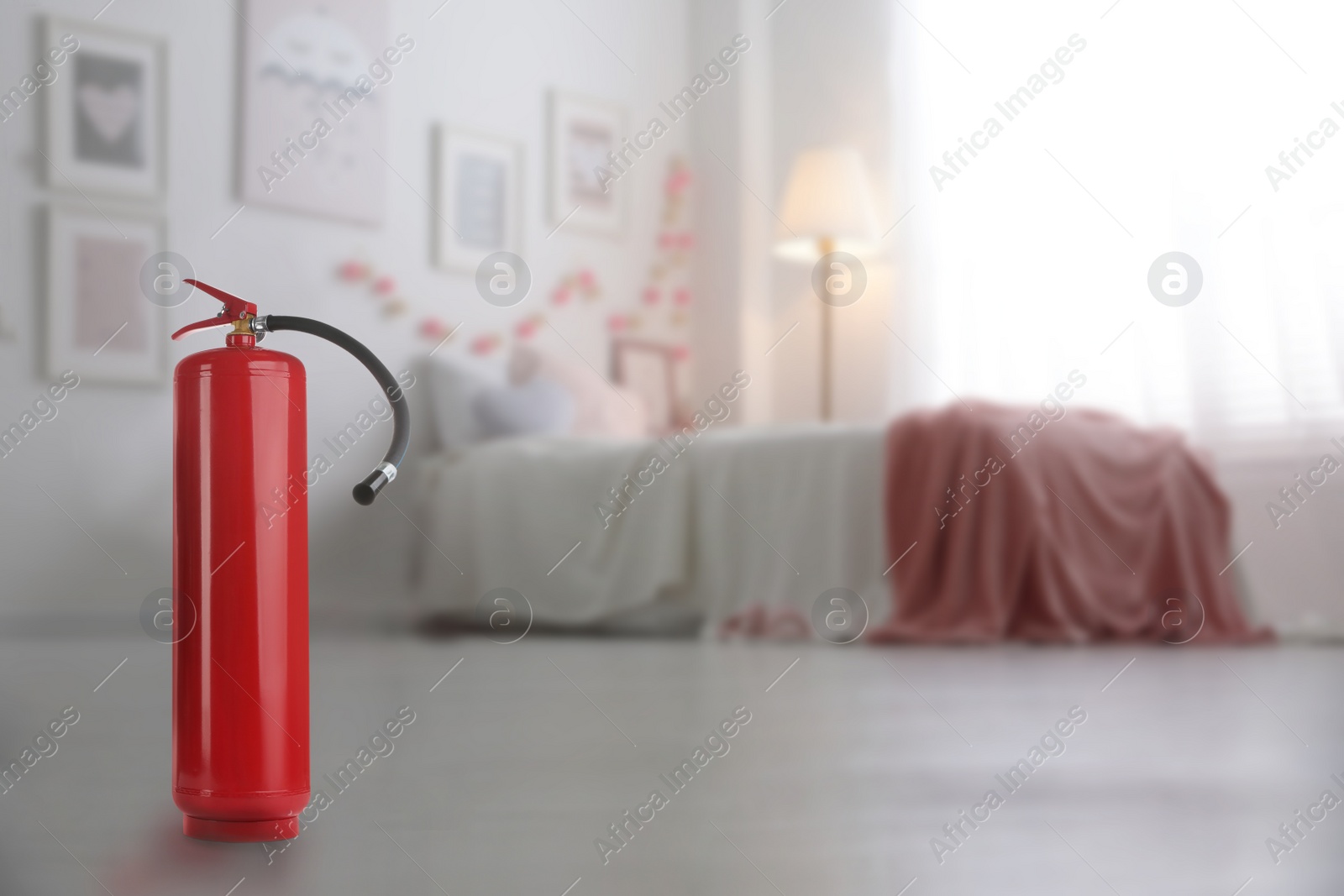 Image of Fire extinguisher on floor in bedroom. Space for text