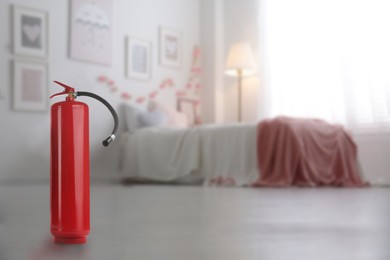 Fire extinguisher on floor in bedroom. Space for text