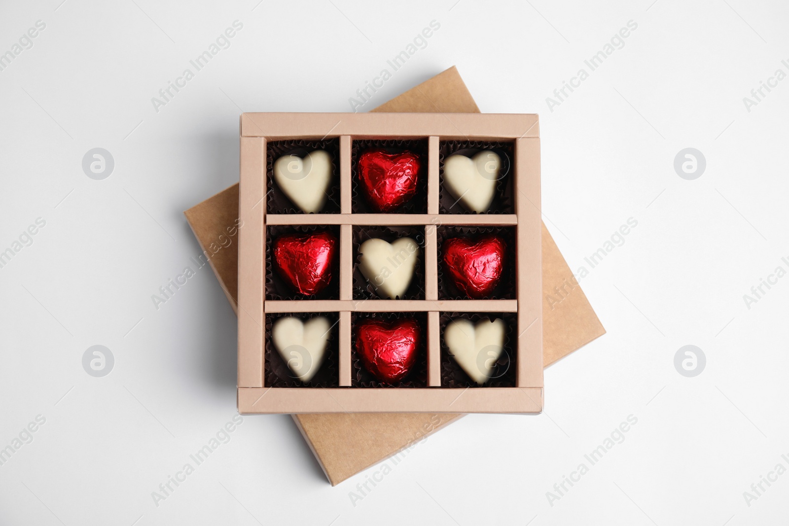 Photo of Tasty heart shaped chocolate candies on white background, top view. Happy Valentine's day