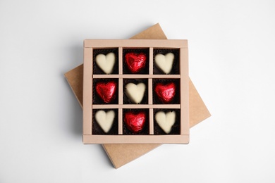 Tasty heart shaped chocolate candies on white background, top view. Happy Valentine's day