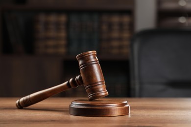 Photo of Wooden gavel on table against blurred background