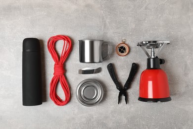Photo of Set of traveler's equipment on grey table, flat lay