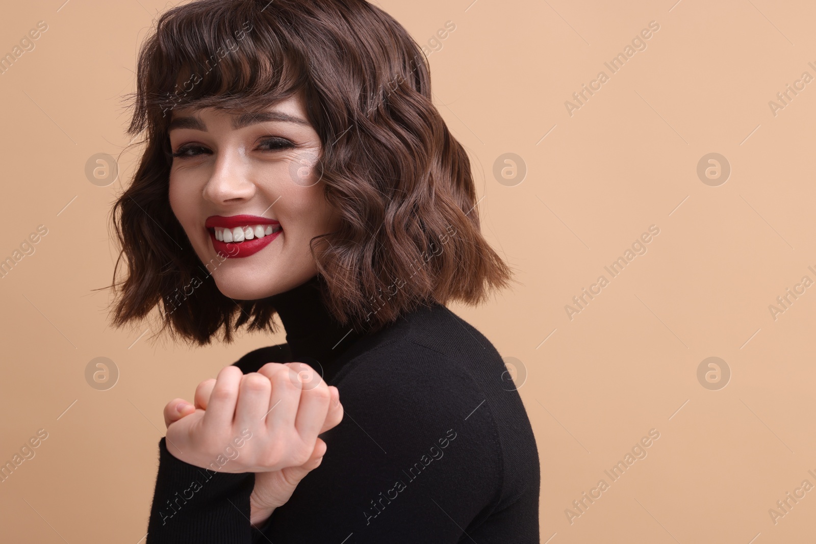 Photo of Portrait of beautiful young woman with wavy hairstyle on beige background. Space for text