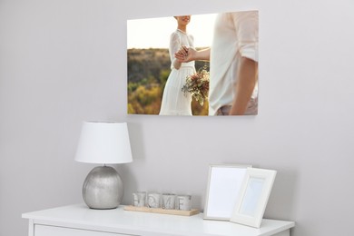 Image of Canvas with printed photo of happy newlywed couple on white wall in room