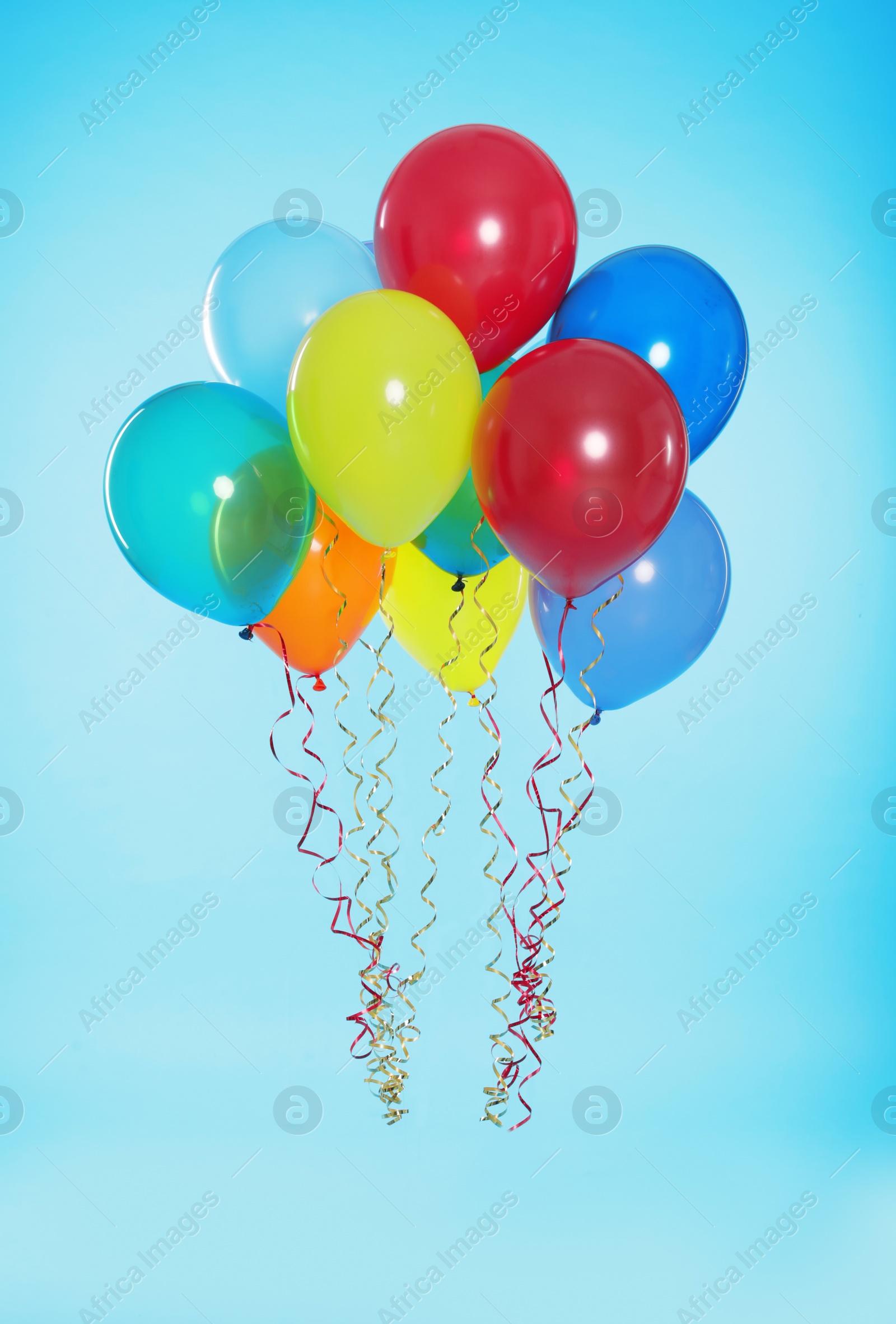 Photo of Many bright balloons floating on color background