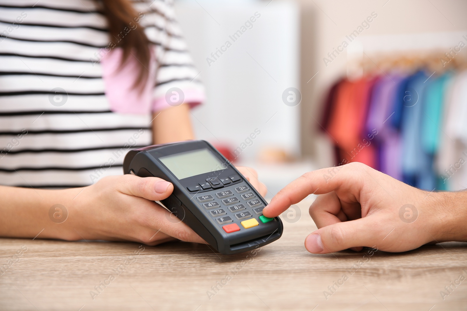 Photo of Man using terminal for contactless payment in shop, closeup