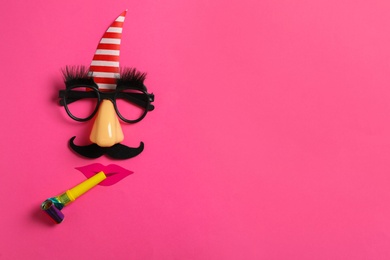 Photo of Funny face made with clown's accessories on pink background, flat lay. Space for text