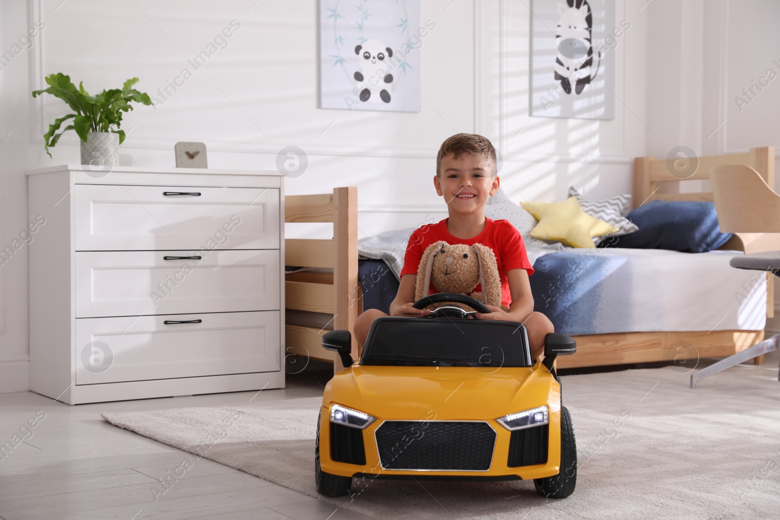 Photo of Cute little boy driving big toy car at home, space for text