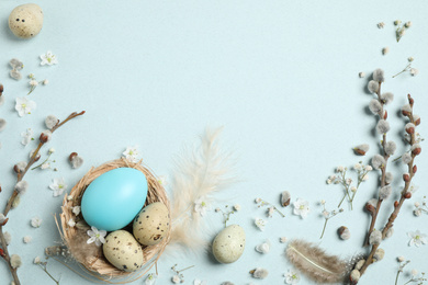 Photo of Beautiful flat lay composition with flowers and Easter eggs on light background. Space for text