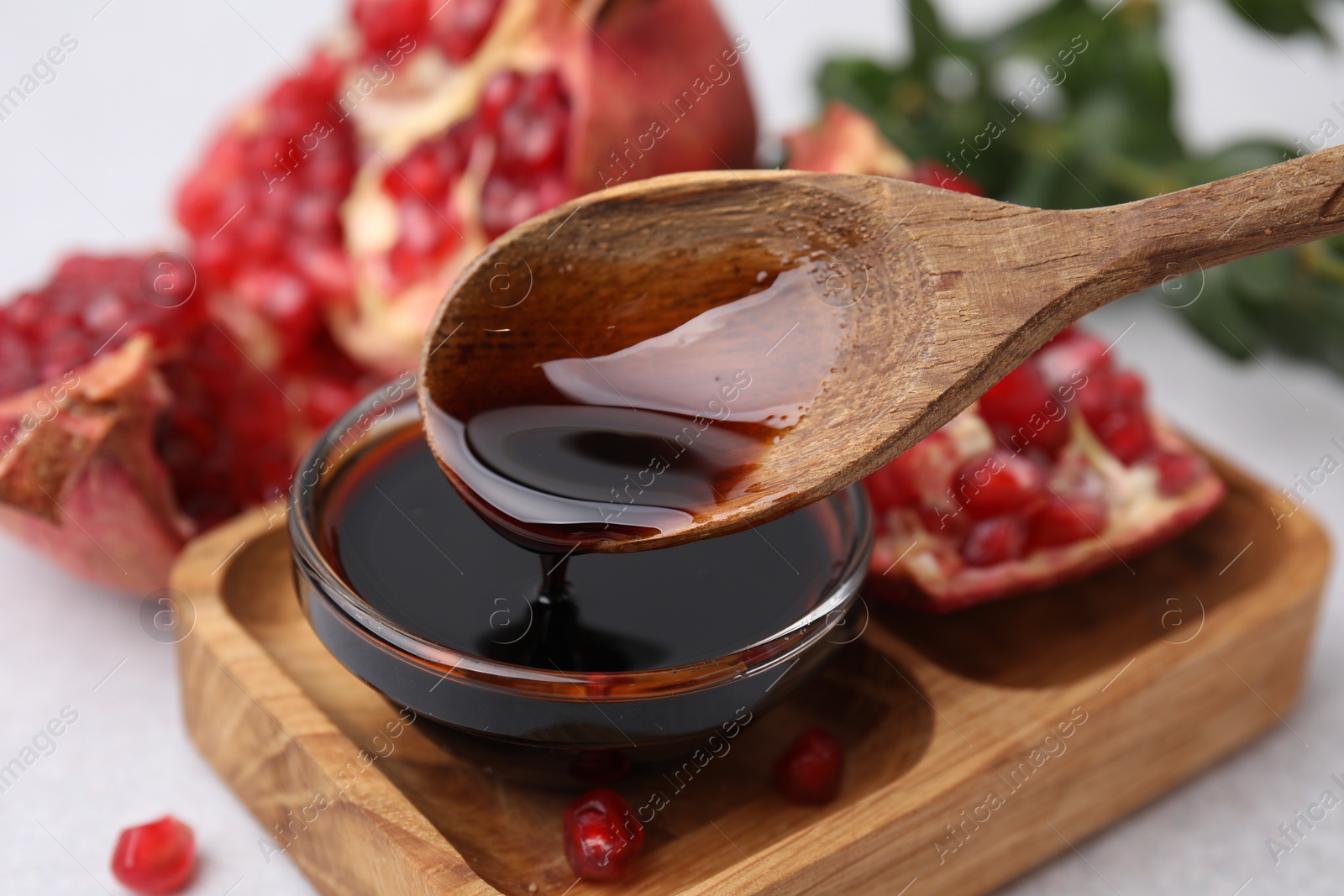 Photo of Tasty pomegranate sauce on light table, closeup