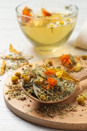 Photo of Mix of dried herbs and tea on white wooden table