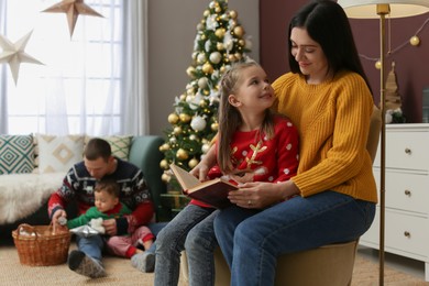 Photo of Happy family spending time together in room decorated for Christmas