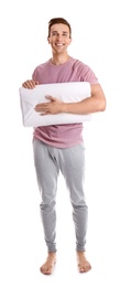 Photo of Young man in pajamas with pillow on white background