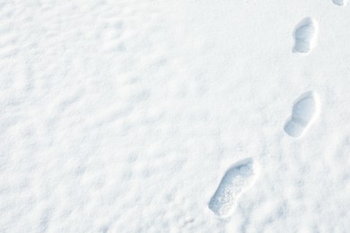 Photo of Footprints on white snow outdoors, space for text. Winter weather