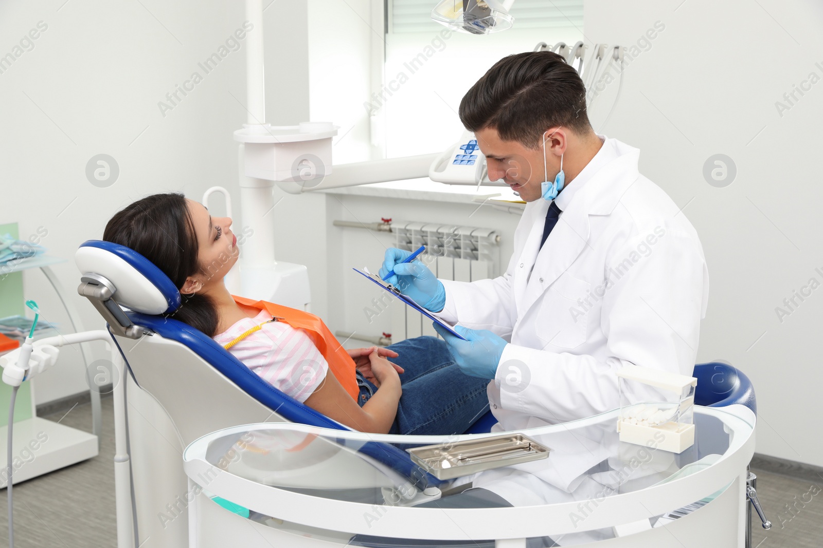 Photo of Professional dentist working with patient in clinic