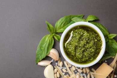 Photo of Flat lay composition with pesto sauce and ingredients on grey table. Space for text