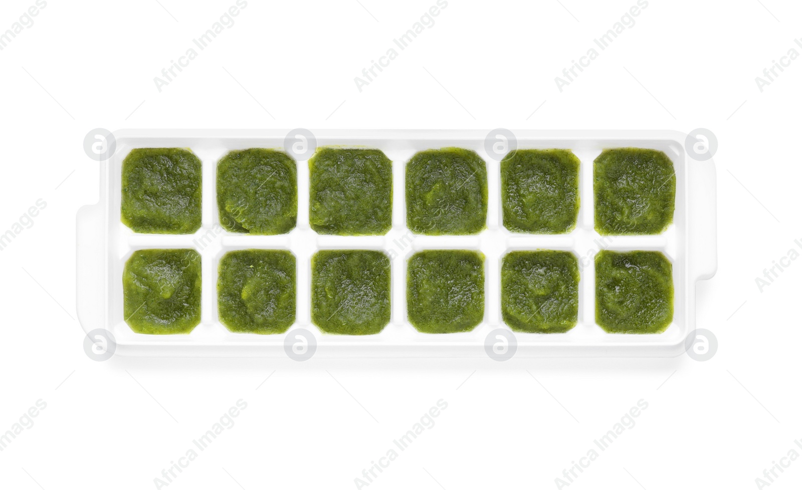 Photo of Broccoli puree in ice cube tray isolated on white, top view. Ready for freezing