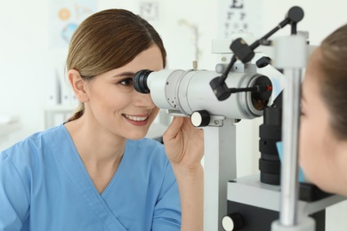 Photo of Ophthalmologist examining little girl in clinic