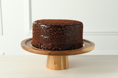 Delicious chocolate truffle cake on light wooden table