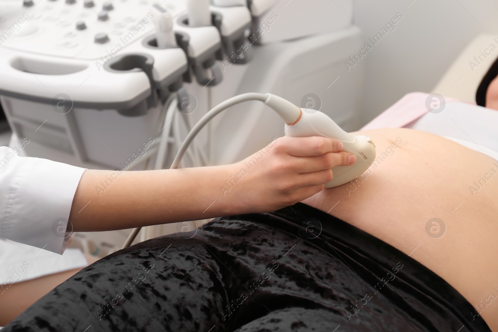 Photo of Pregnant woman undergoing ultrasound scan in clinic, closeup