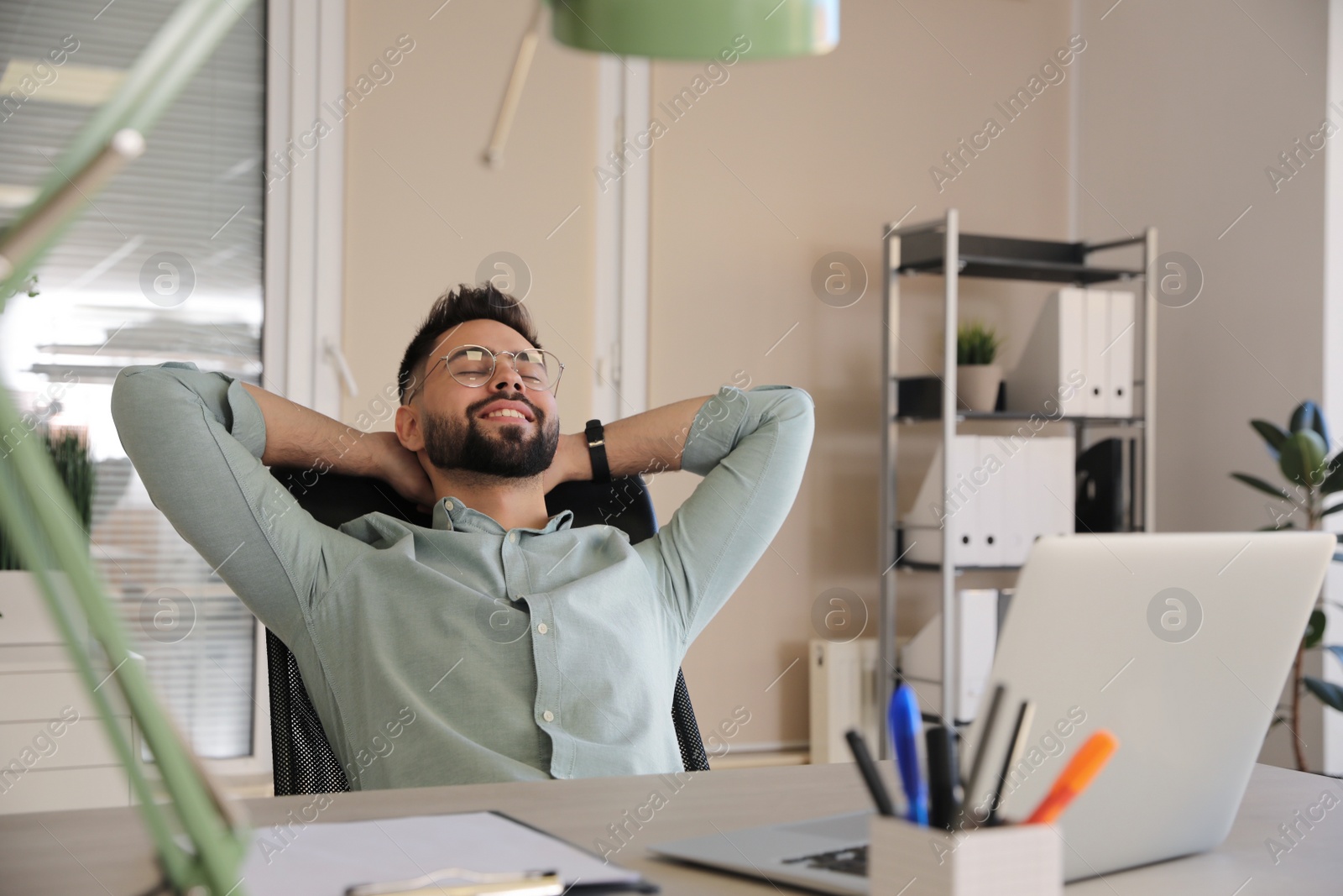 Photo of Businessman relaxing in office chair at workplace