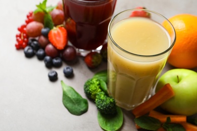 Photo of Delicious juice and fresh ingredients on grey table, closeup. Space for text