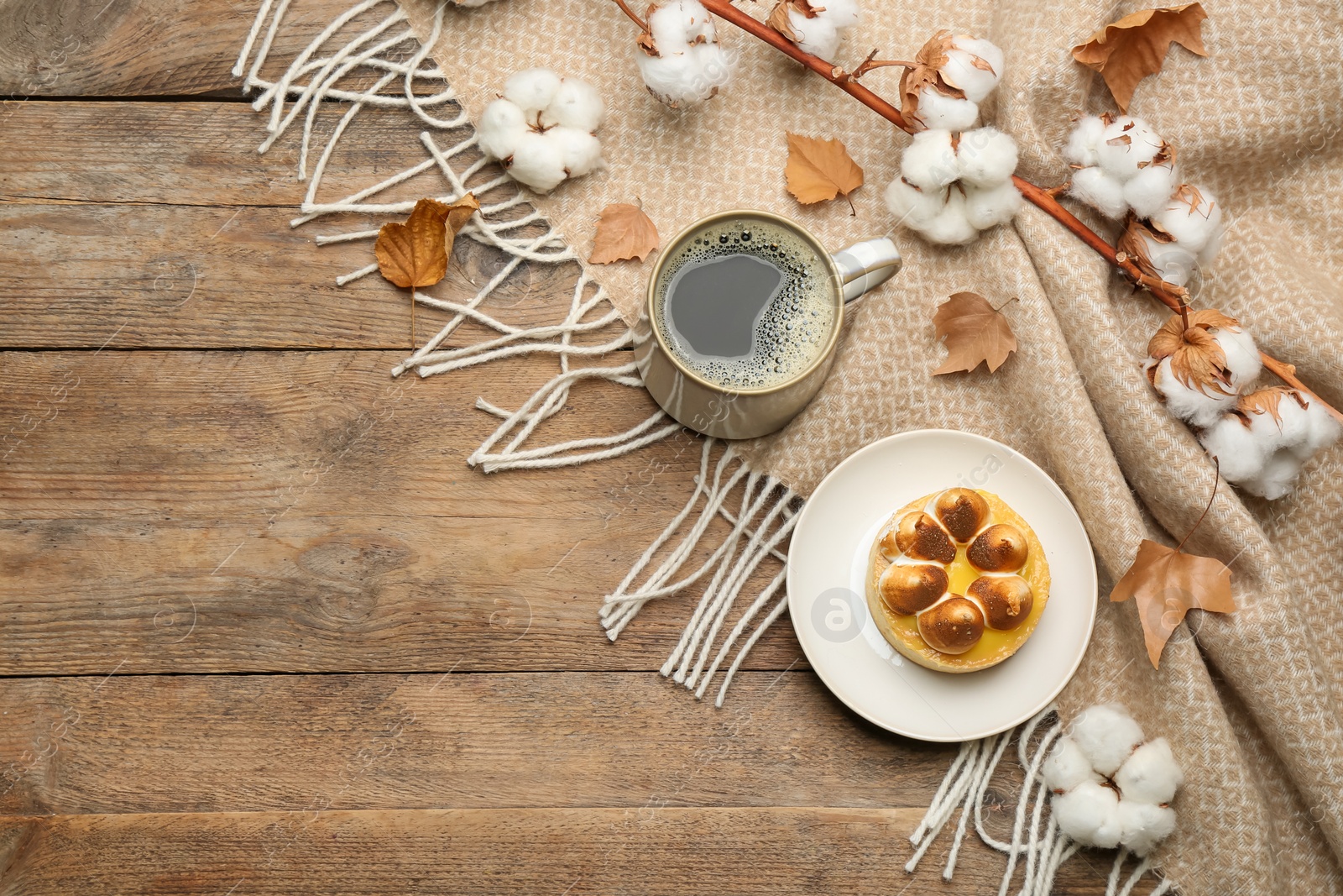 Photo of Flat lay composition with hot drink and warm plaid on wooden table, space for text