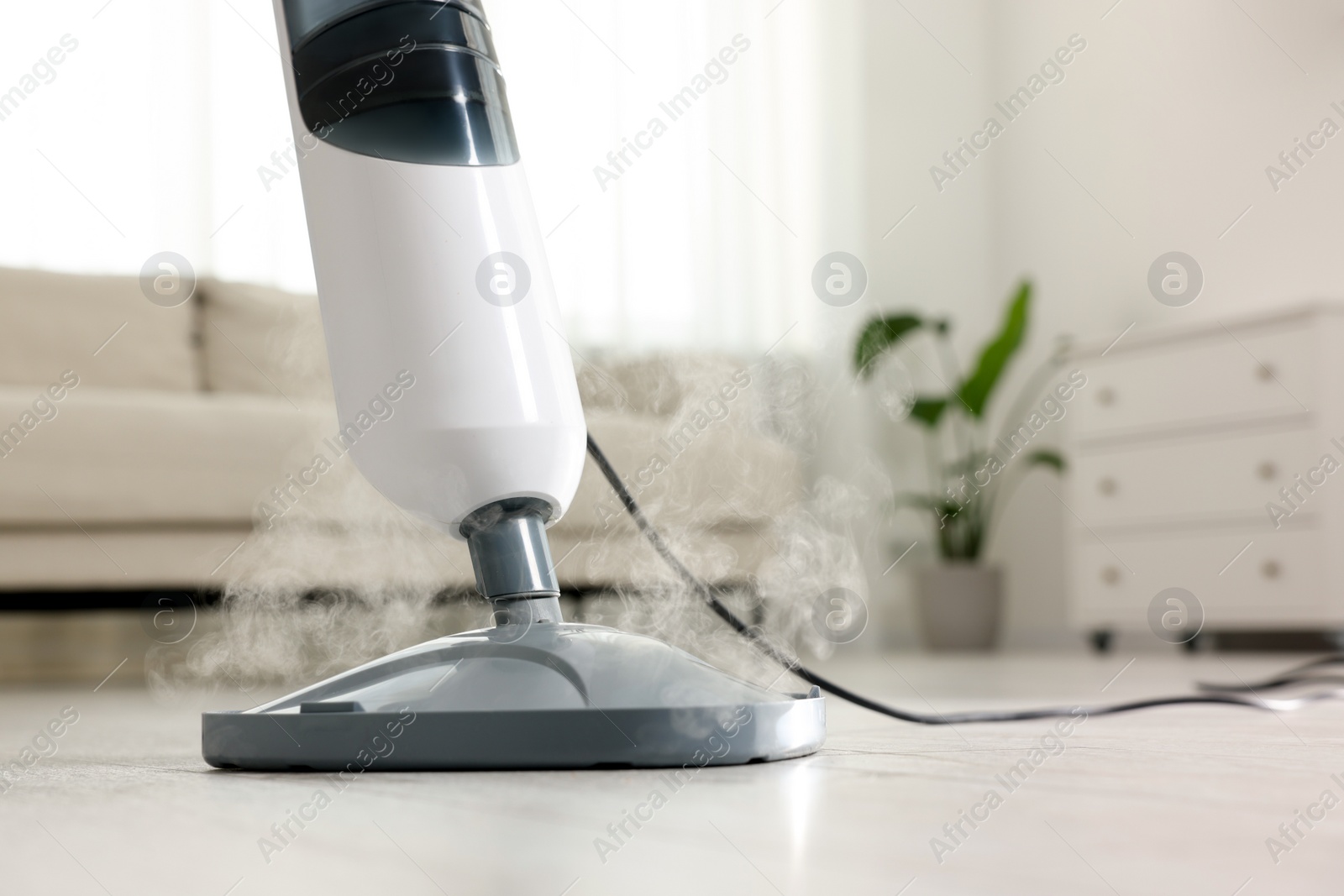 Photo of Cleaning floor with steam mop at home, closeup. Space for text
