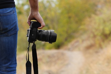 Photographer with professional camera in countryside closeup