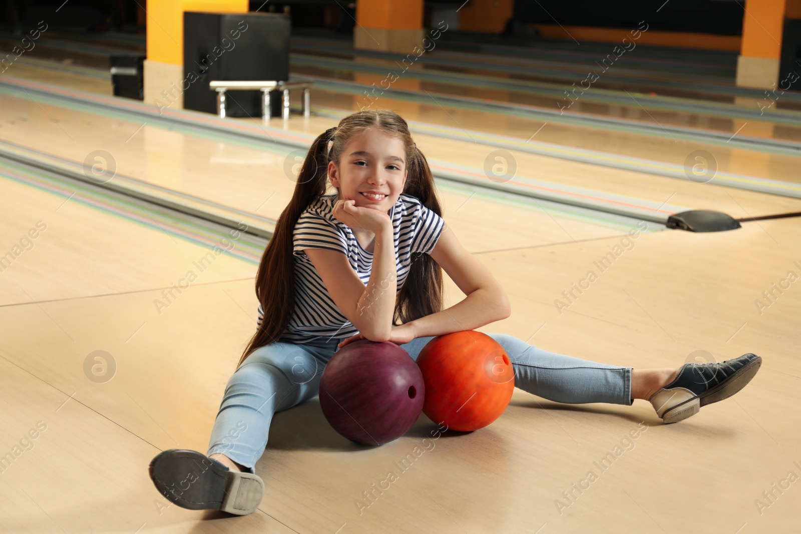 Photo of Preteen girl with balls in bowling club