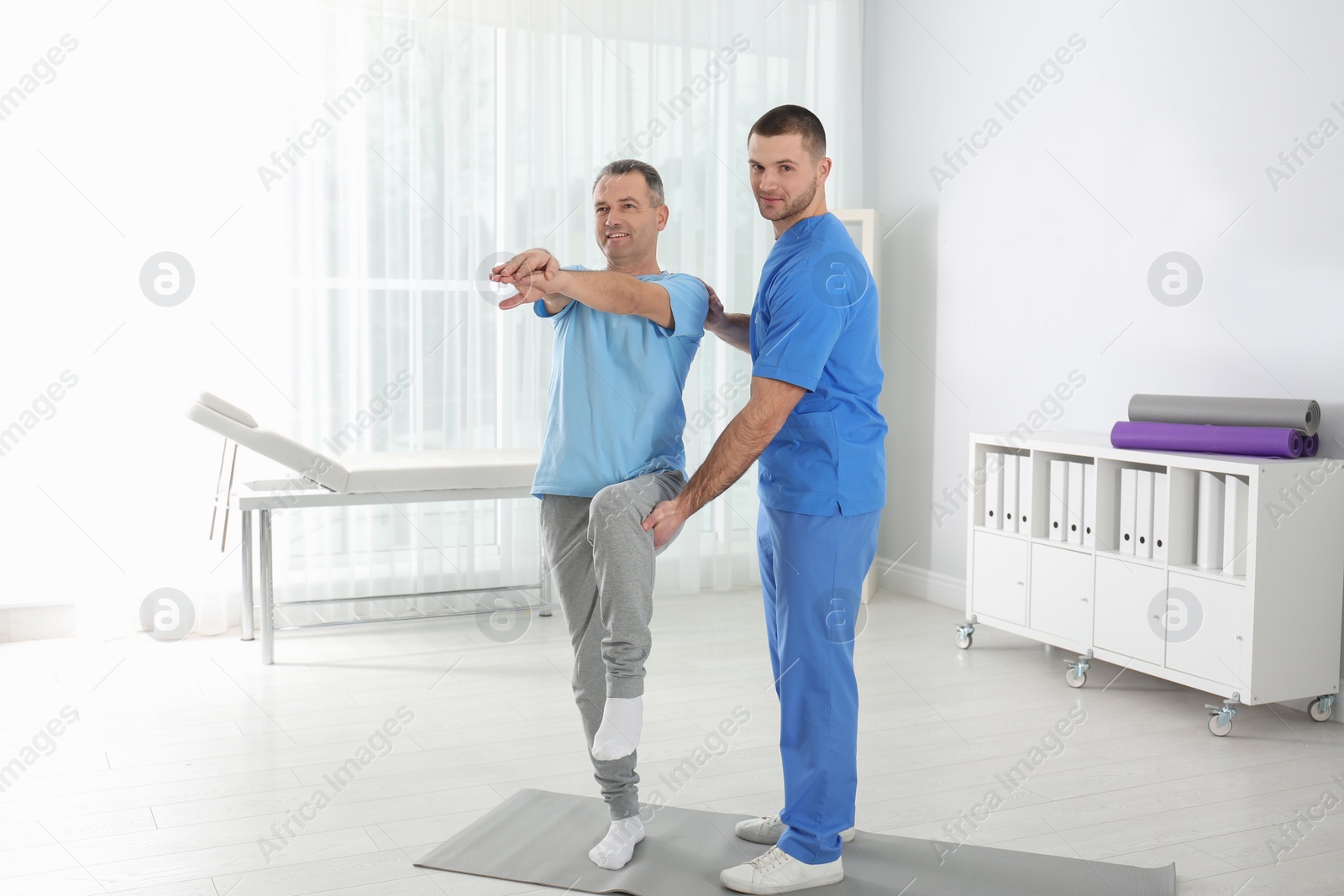 Photo of Doctor working with patient in hospital. Rehabilitation exercises