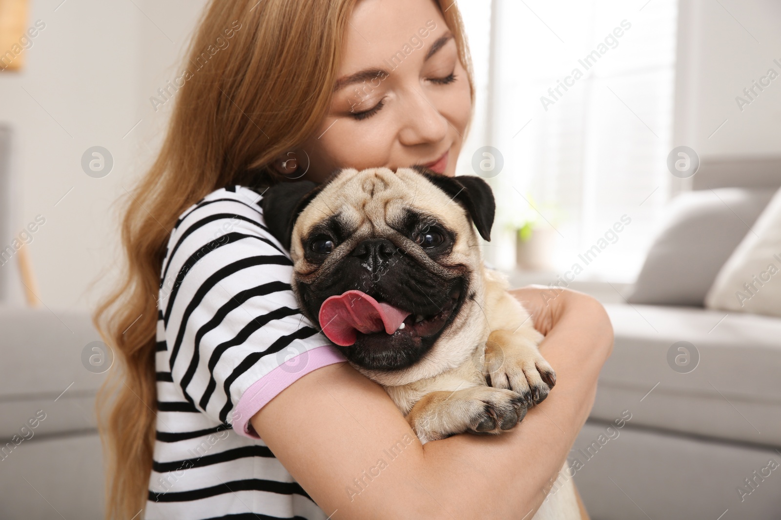 Photo of Woman with cute pug dog at home. Animal adoption