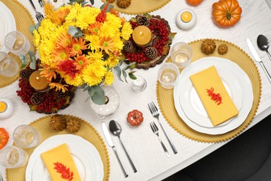 Autumn table setting with floral decor and pumpkins, top view