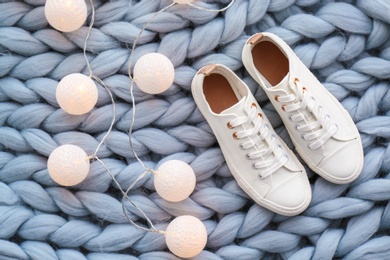 Photo of Comfortable casual female shoes on knitted rug