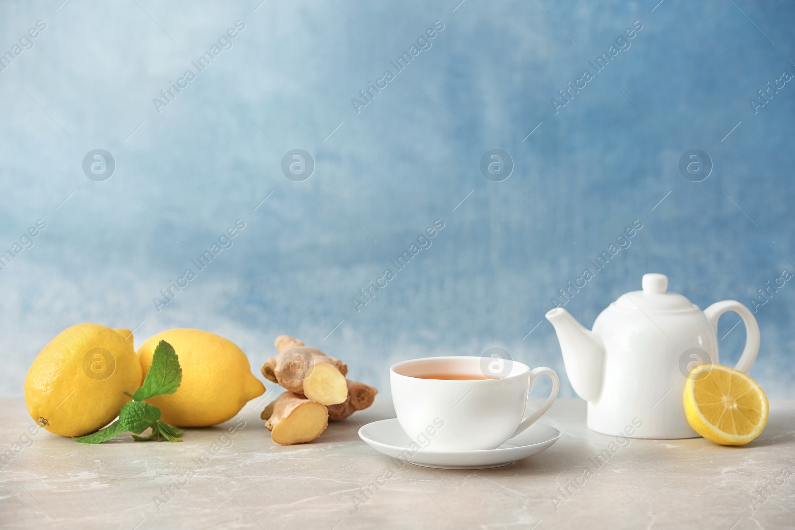 Photo of Composition with lemon tea and ingredients on table