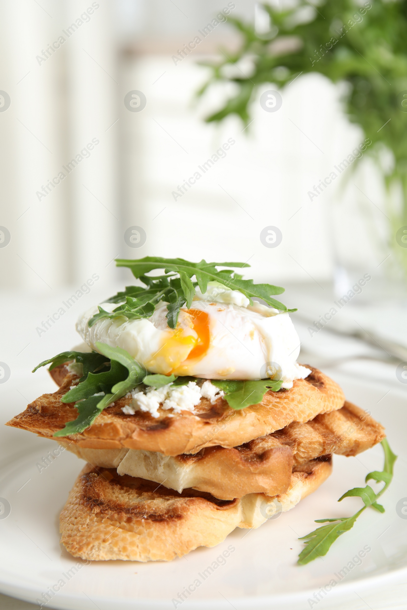 Photo of Delicious sandwich with arugula and egg on white plate