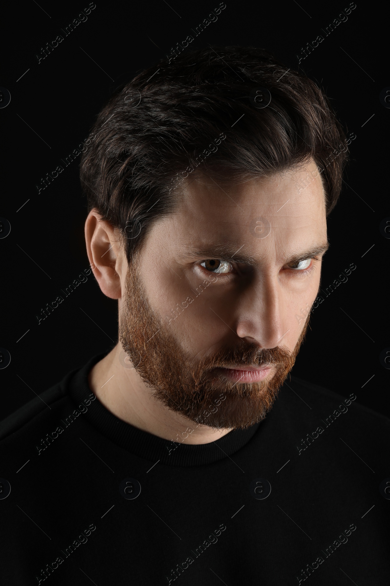 Photo of Evil eye. Man with scary eyes on black background