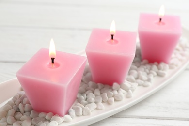 Photo of Composition with three burning candles on white wooden table