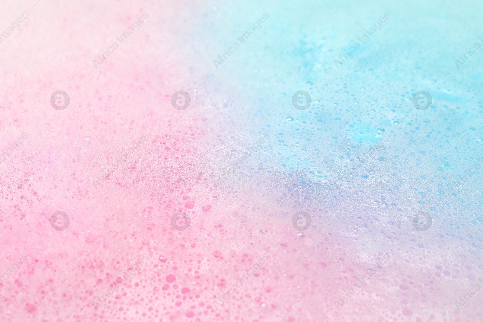 Photo of Colorful foam after dissolving bath bomb in water, closeup