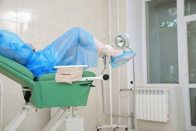 Photo of Gynecological checkup. Woman lying on examination chair in clinic, closeup