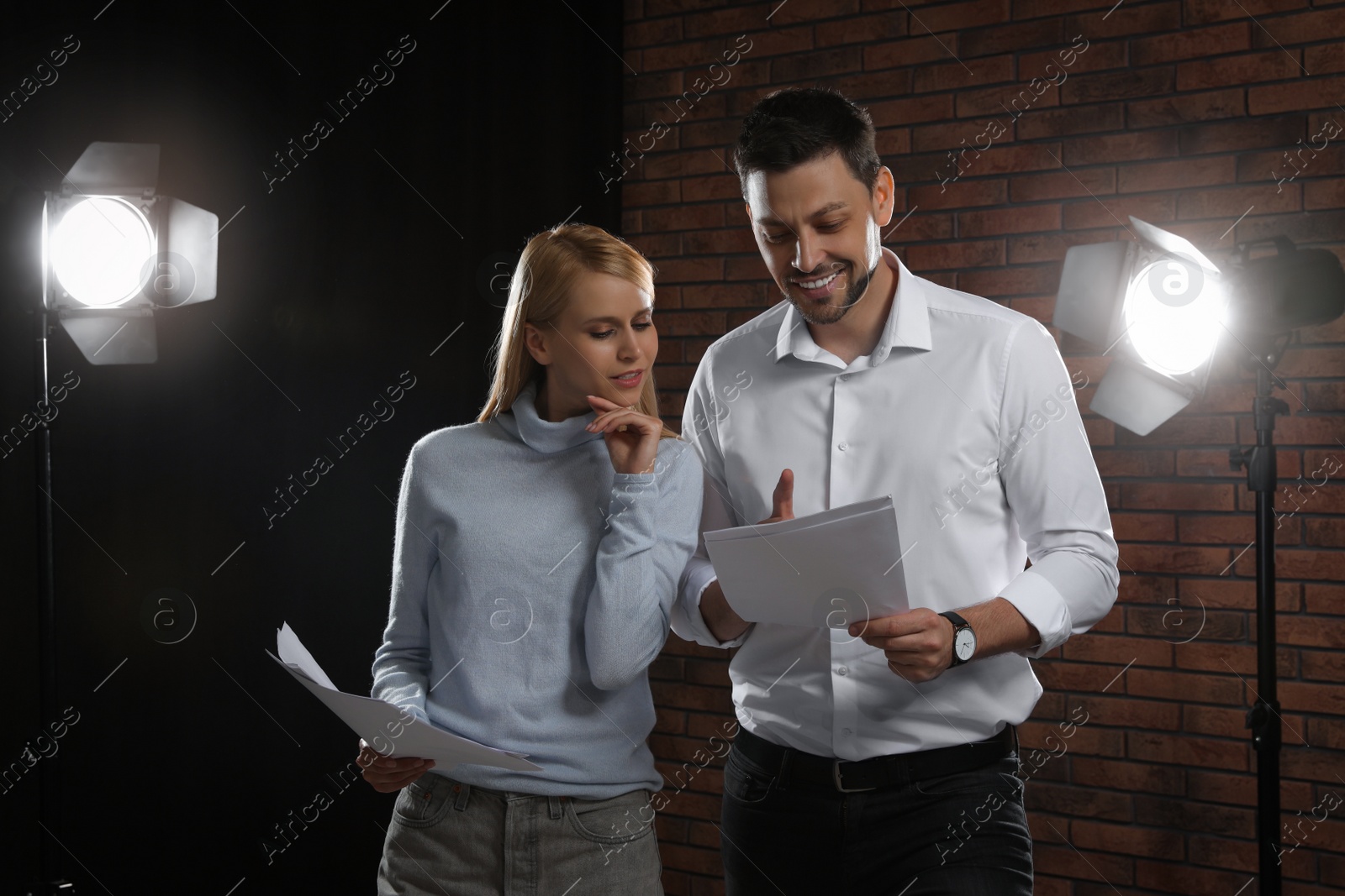 Photo of Professional actors reading their scripts during rehearsal in theatre