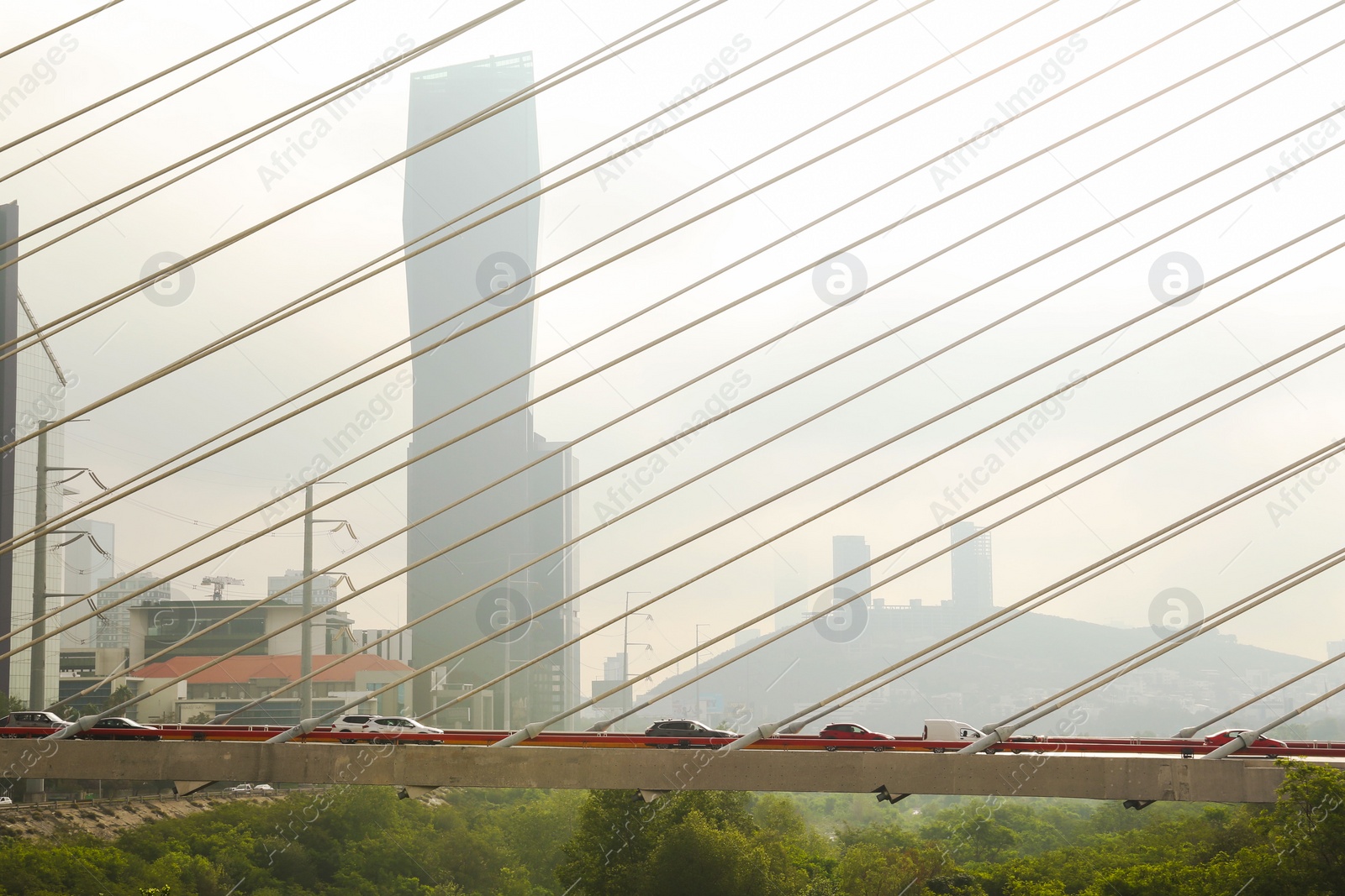 Photo of View of cars on bridge against foggy cityscape